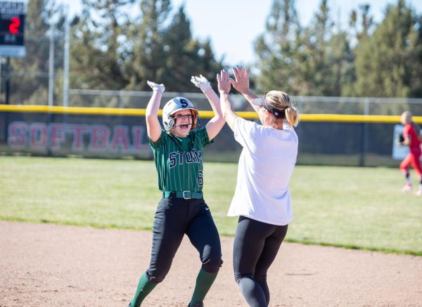 Freshman Autumn Junker celebrates with softball coach Stacy Cox during a game at Mountain View.