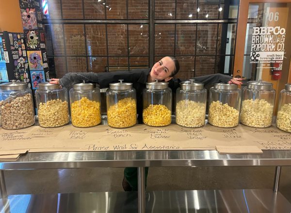 BBPCo employee poses in front of their variety of popcorn