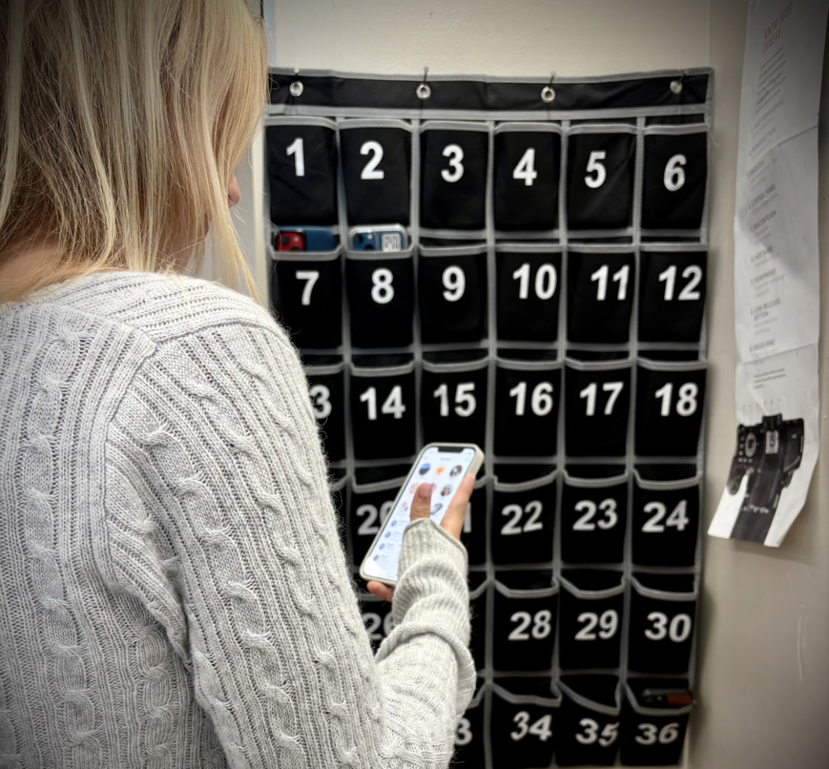 A Summit student places her phone in a phone caddy. / Credit: Caitlin Houston